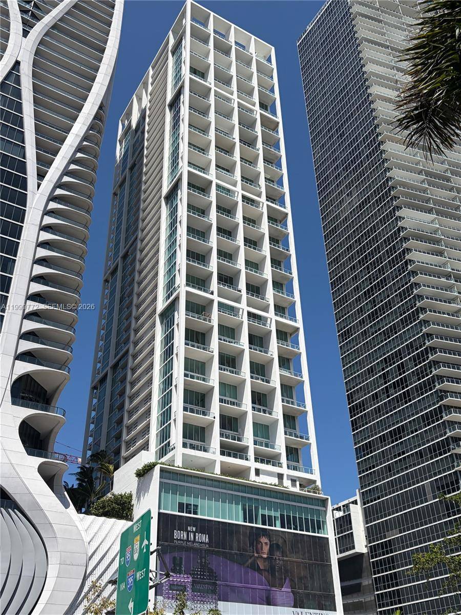 Rarely available corner residence at Ten Museum Park offering dramatic two story loft living with soaring ceilings and walls of glass showcasing the breathtaking bay, ocean, park, Gov t Cut ...