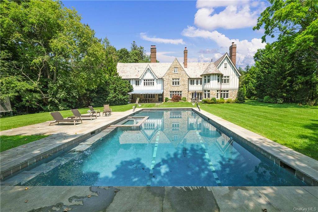 Exceptionally private Manor home with an inviting circular courtyard, oversized inground heated pool and landscaped grounds splays prominently on beautiful parklike 1.