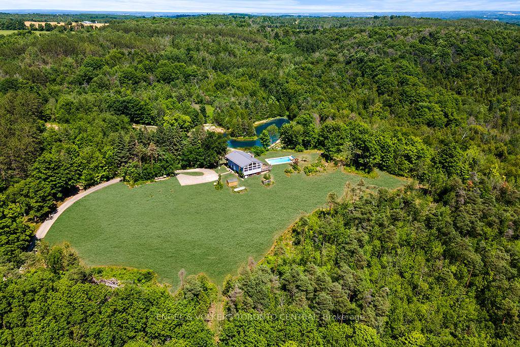 Follow the winding driveway to your private 56 acre retreat in the heart of Mono Township, an extraordinary estate that offers unparalleled tranquility and natural beauty.