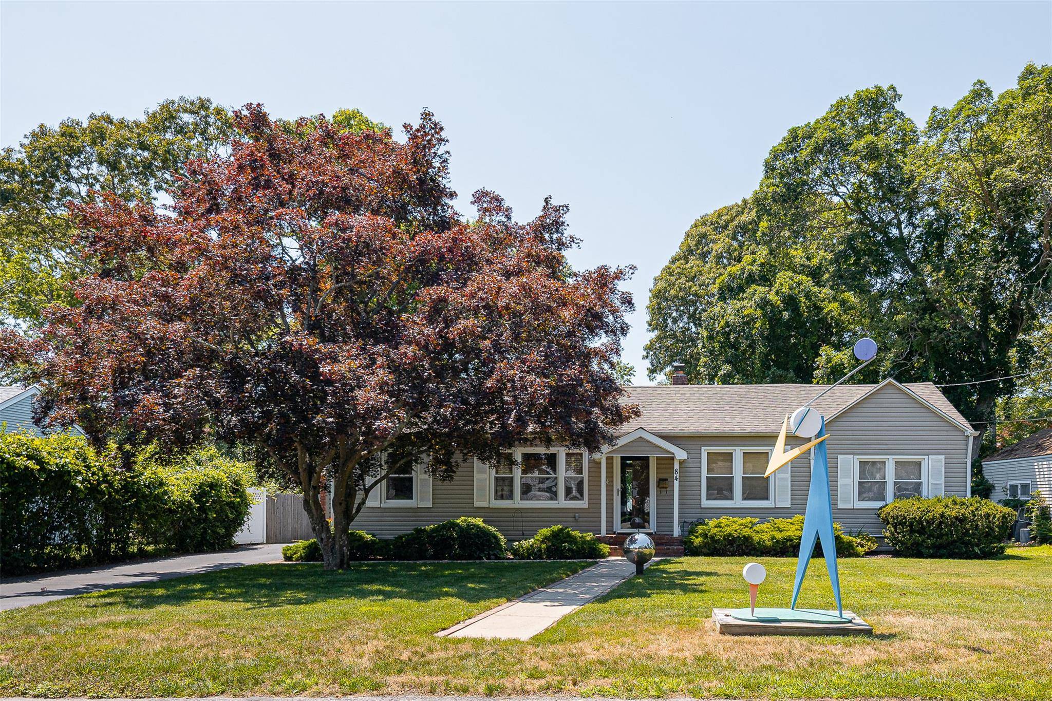 Discover your charming island retreat at 84 Country Club Road in Bellport Village, NY.