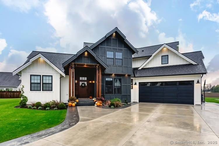 Setback on a wooded lot, this 2, 800 square foot modern farmhouse exudes timeless charm with contemporary elegance.