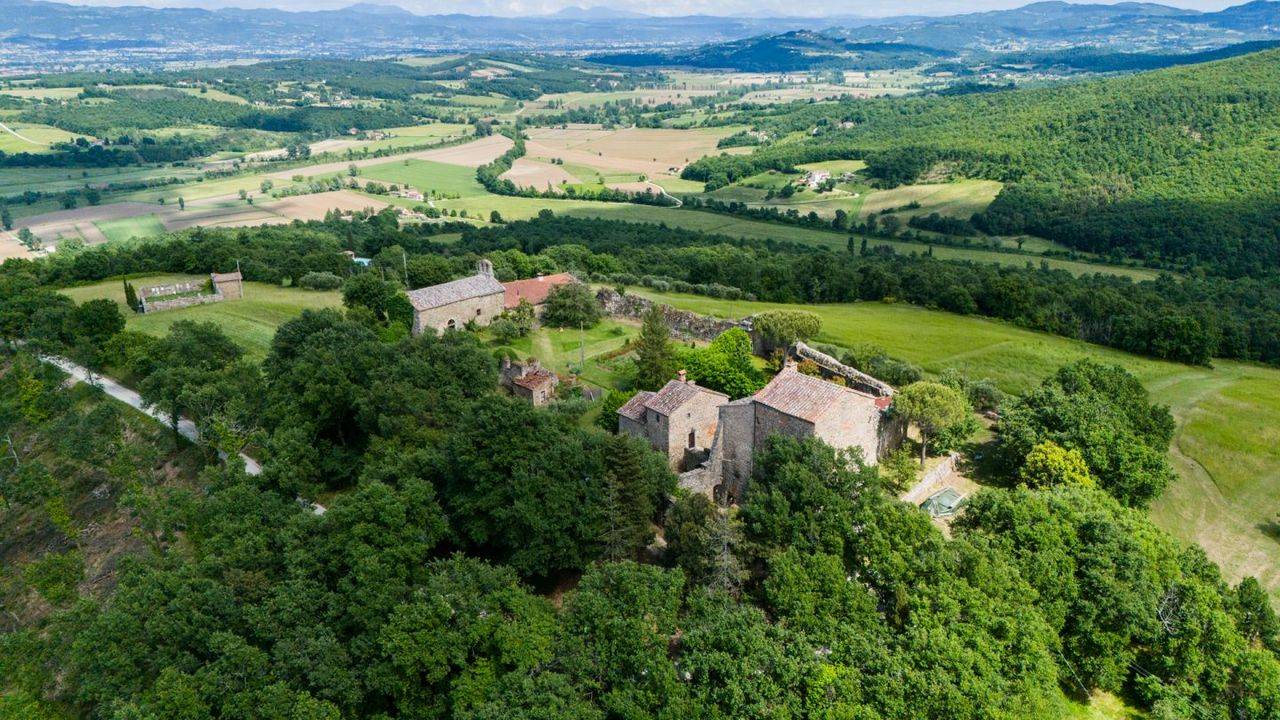 Ancient Tuscan stone real estate consisting of two houses and a ruin, arranged in a circle, in the original structure of the fortress.