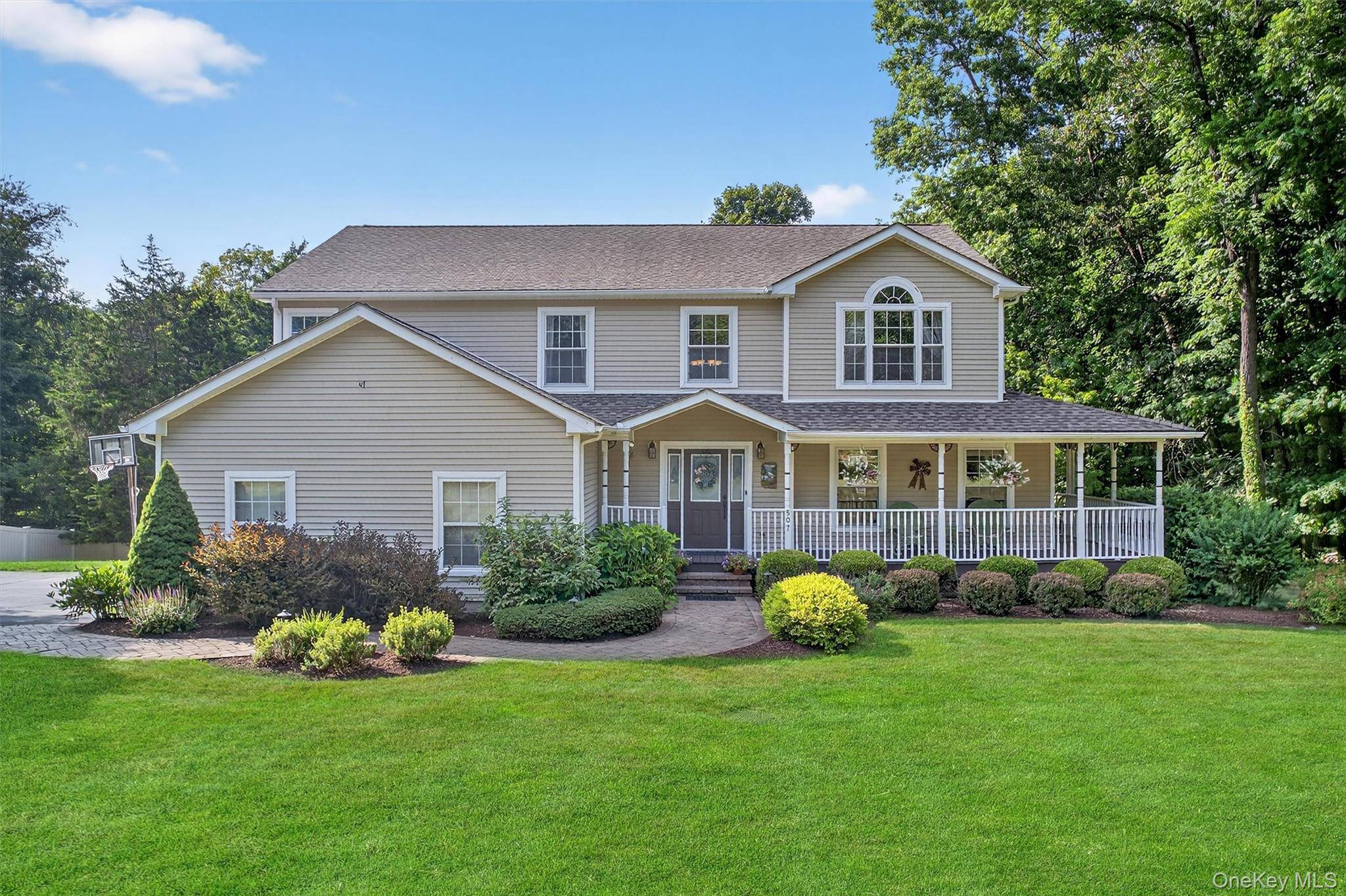 Welcome to this beautifully maintained colonial with a charming wrap around front porch, set on 1.