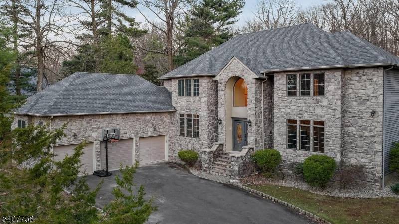 Nestled on a quiet cul de sac and set on a private wooded lot, this elegant Colonial home boasts a striking stone exterior and timeless curb appeal.