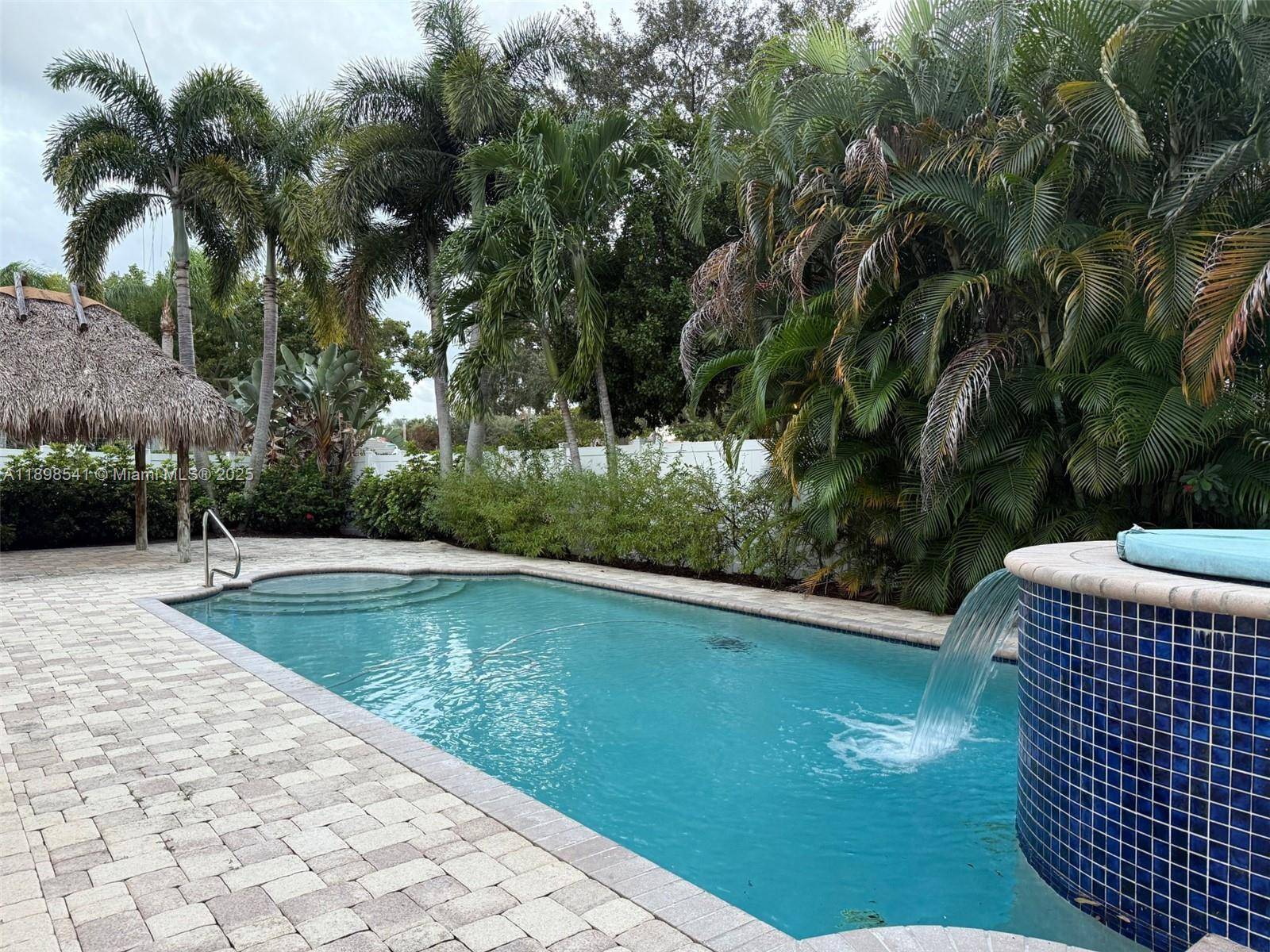 Welcome to your private South Florida Oasis with a heated saltwater pool with a waterfall, an oversized lot, an outdoor shower and amazing Tiki hut for shade and privacy !