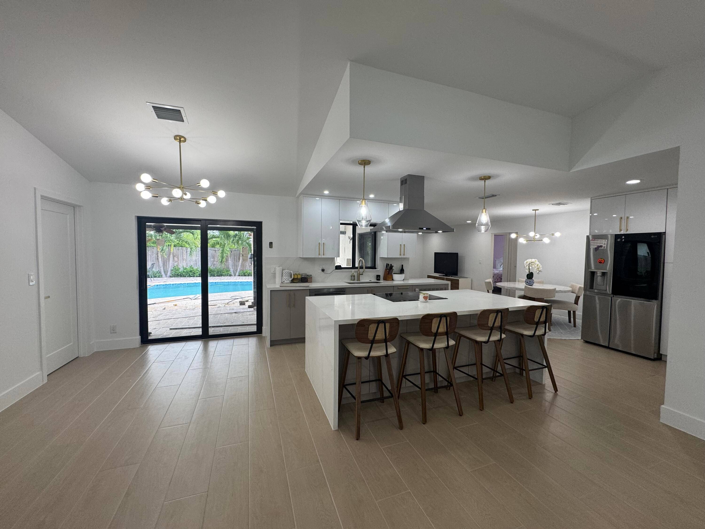 This stunning, completely renovated home boasts a central kitchen that opens up to both the family and living rooms, creating a spacious, open concept layout that's perfect for entertaining.