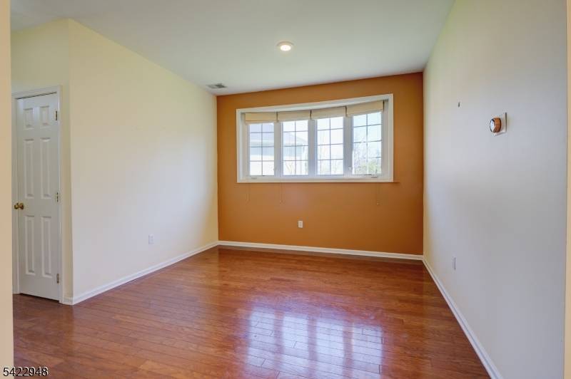 Filled with natural light, the home features wood flooring throughout the main level and a beautifully updated kitchen with granite countertops, stainless steel appliances, and a newer dishwasher.
