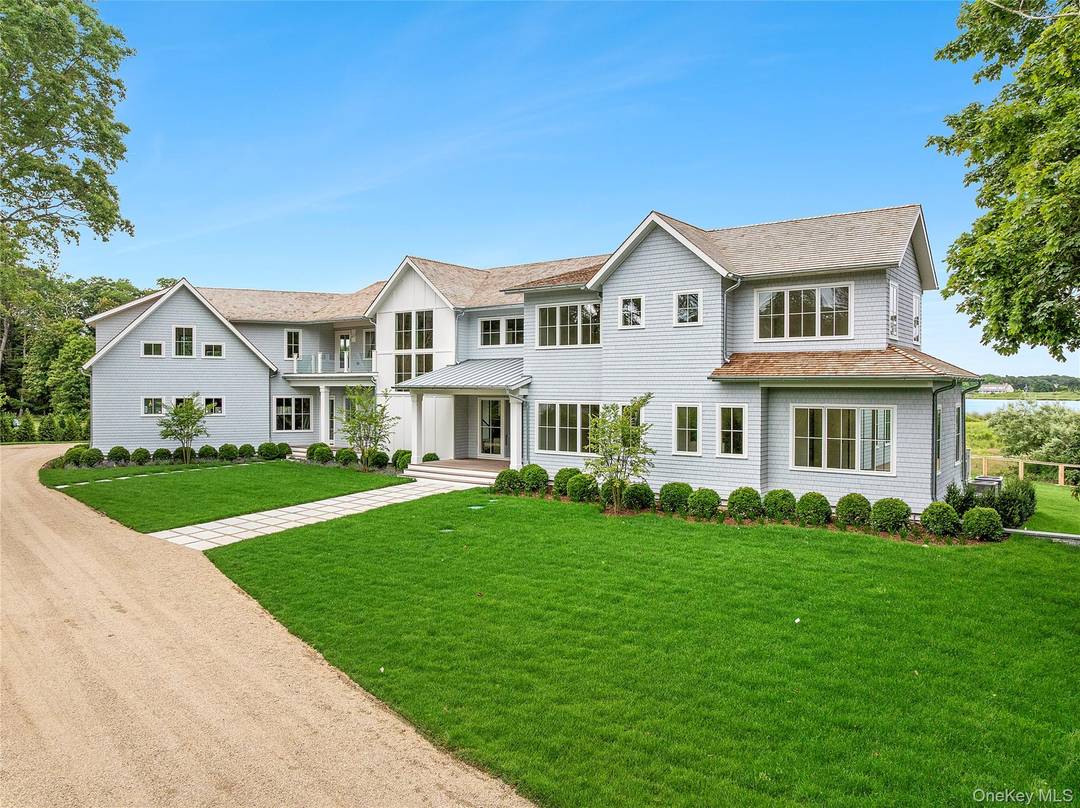 Discover the ultimate in luxury living on 3 private acres with 225 feet of bulkhead along the serene Quantuck Creek in Quiogue.