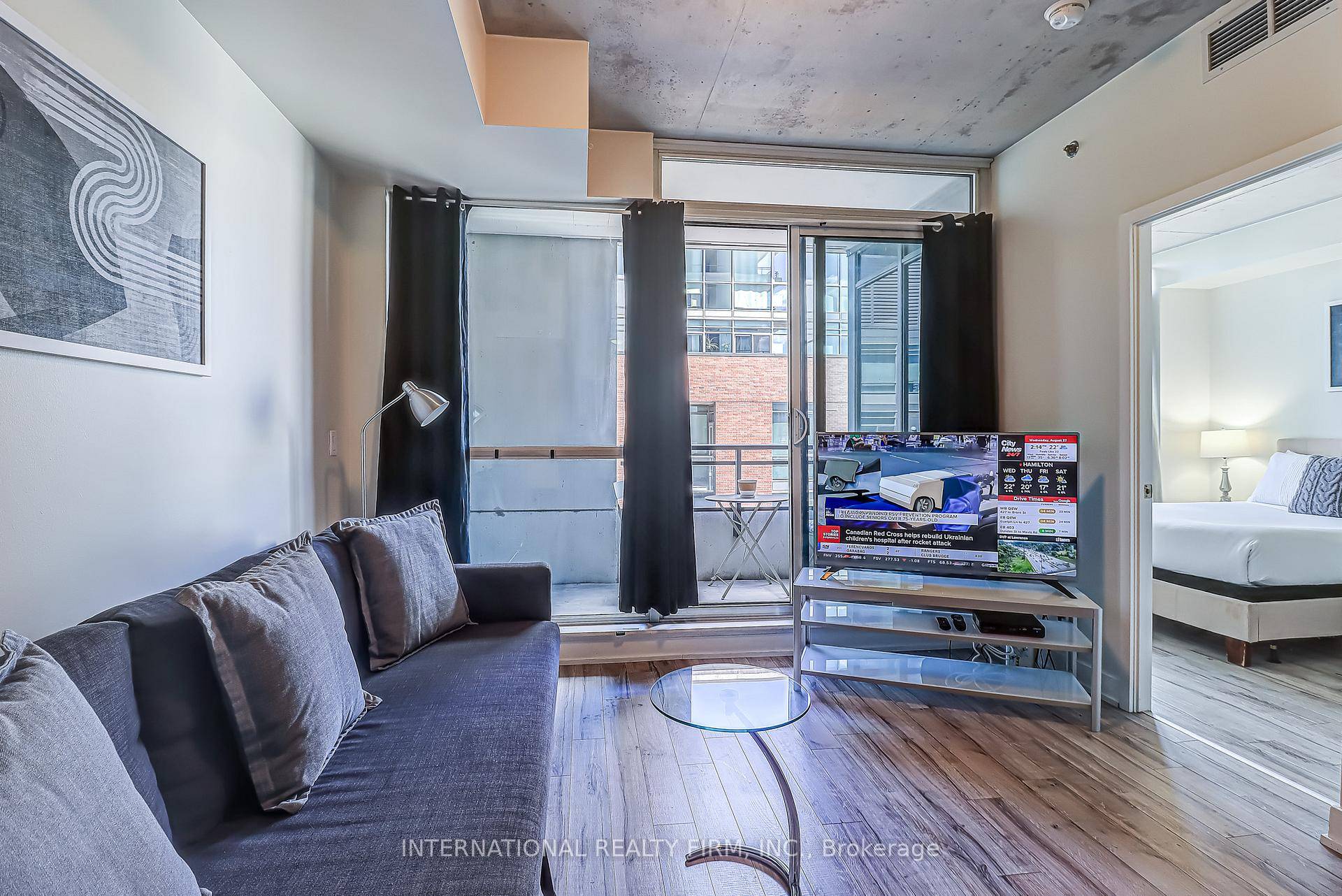 Modern 1 bedroom furnished condo at the Carnaby Lofts in Queen West featuring floor to ceiling windows, a sleek kitchen with built in appliances, in suite laundry, and a private ...