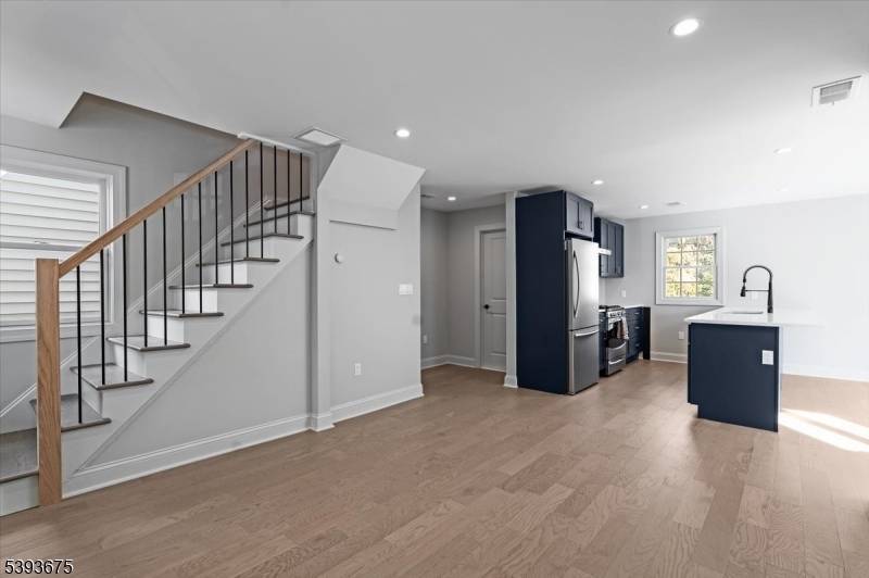 Newly renovated rental offering a modern kitchen with stainless steel appliances flowing seamlessly into a bright family room.