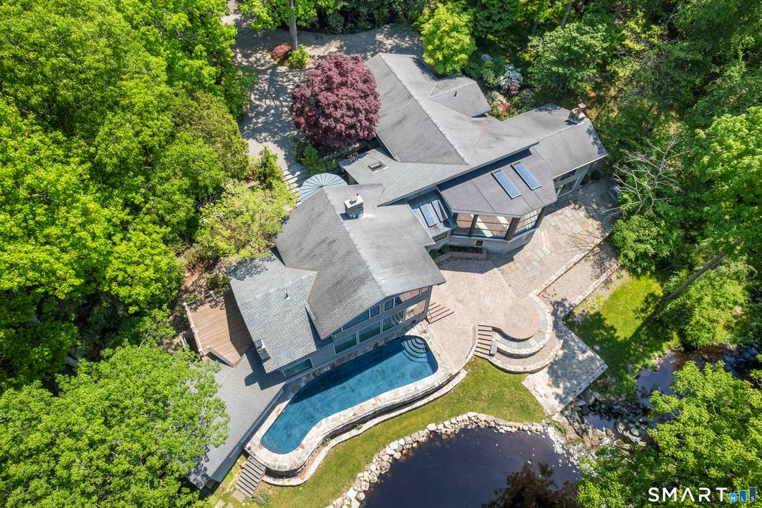 Extraordinary riverfront modern retreat set against a breathtaking backdrop of waterfall, woodland, and sweeping water views in one of Weston's most remarkable settings.