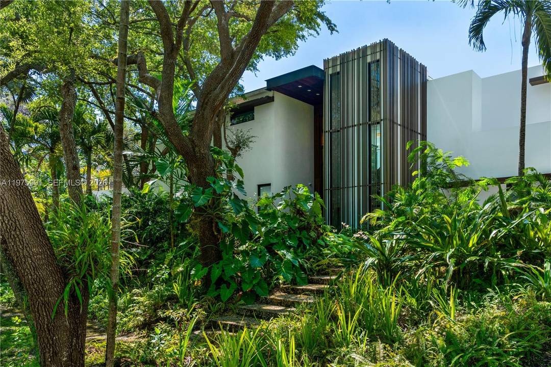 Completed in 2019 by Norway Builders, this exceptional residence sits on a coral ridge along a quiet, tree lined street on a lush acre lot.