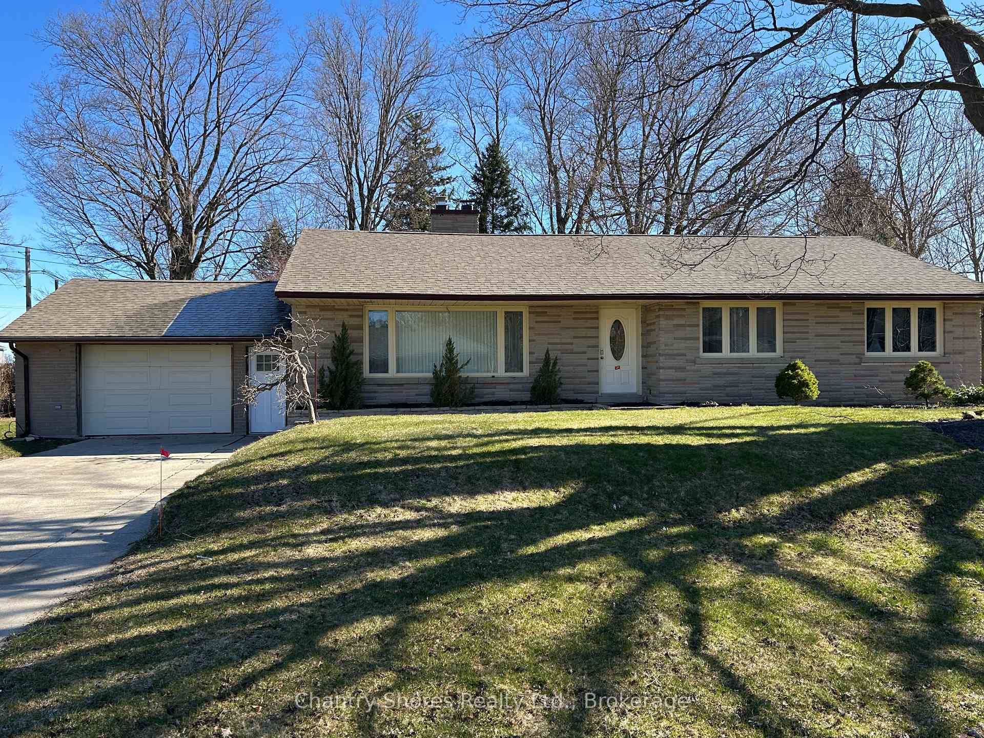 Rarely offered large brick bungalow with attached garage on a lovely mature double corner town lot 132' x 132'.