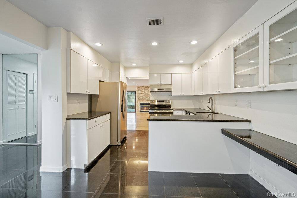 Sun drenched Adventura Model with new wood flooring, a custom quartz mantled fireplace, two new compressors and double hot water heaters.