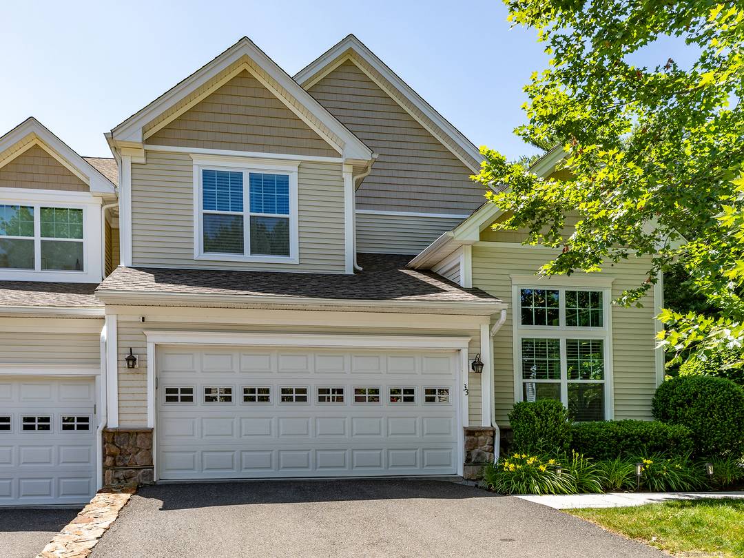 Walls of windows ! Spectacular, light filled end unit at an award winning townhome community in Middlebury.
