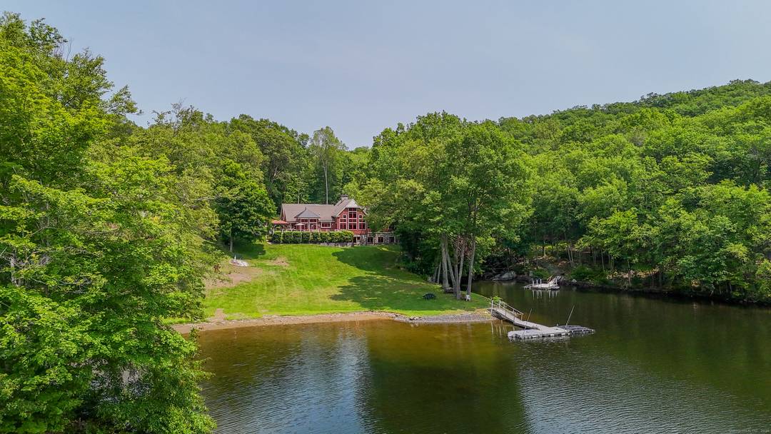 Grand post and beam home with level lake frontage and views, babbling brook, main level master suite, 9 car garage, finished walk out, and unfinished loft spaces for potential for ...