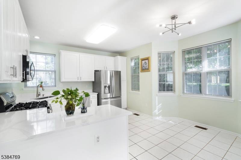 UPDATE ALERT ! Freshly painted, the kitchen has been elevated with Quartz countertops, stainless steel sink, elegant light fixture, freshly painted cabinets accented with new hardware.