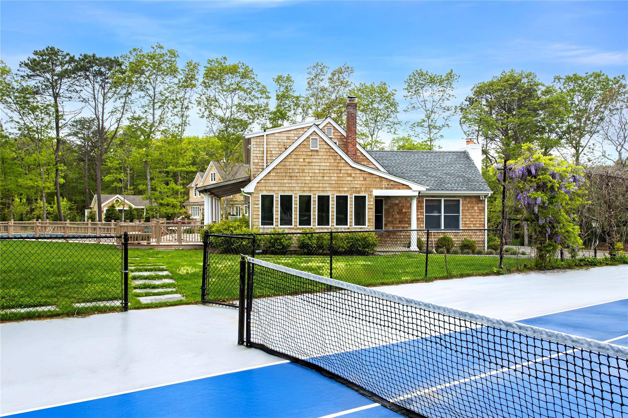 Located in Quogue, this beautiful home sits at the end of a long driveway, past your all weather tennis court.