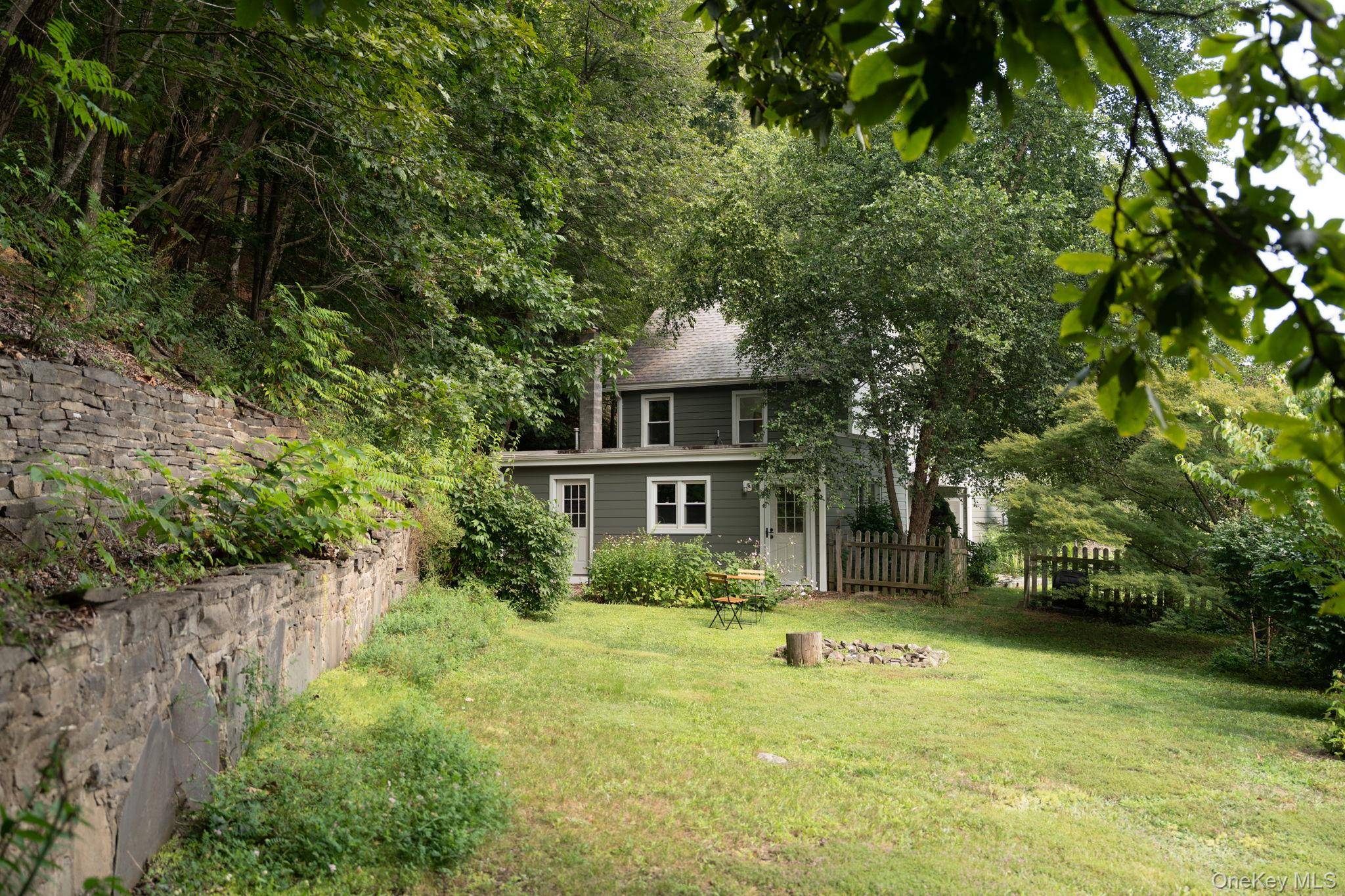 Stone Walls is an updated classic, nestled into a flat lot lined by striking old bluestone walls and lush landscape.