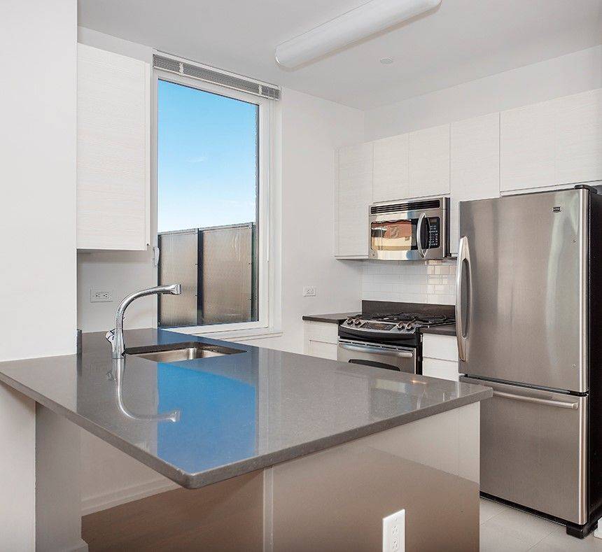 Spacious 1 bedroom with a gourmet open kitchen with window and stainless steel appliances, stone countertops and eating bar.