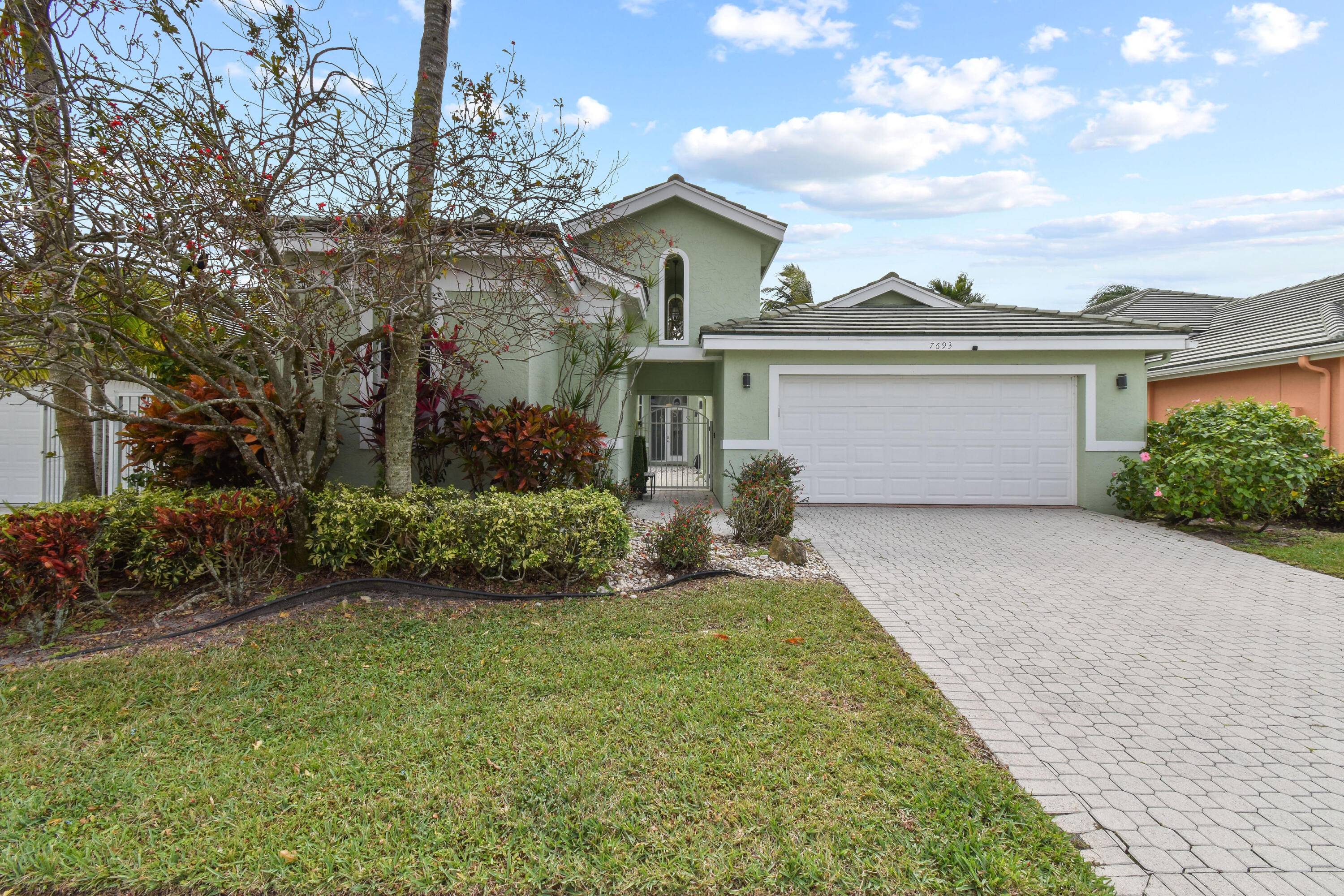 Welcome to your dream home nestled within the prestigious confines of a lush South Florida golf community.