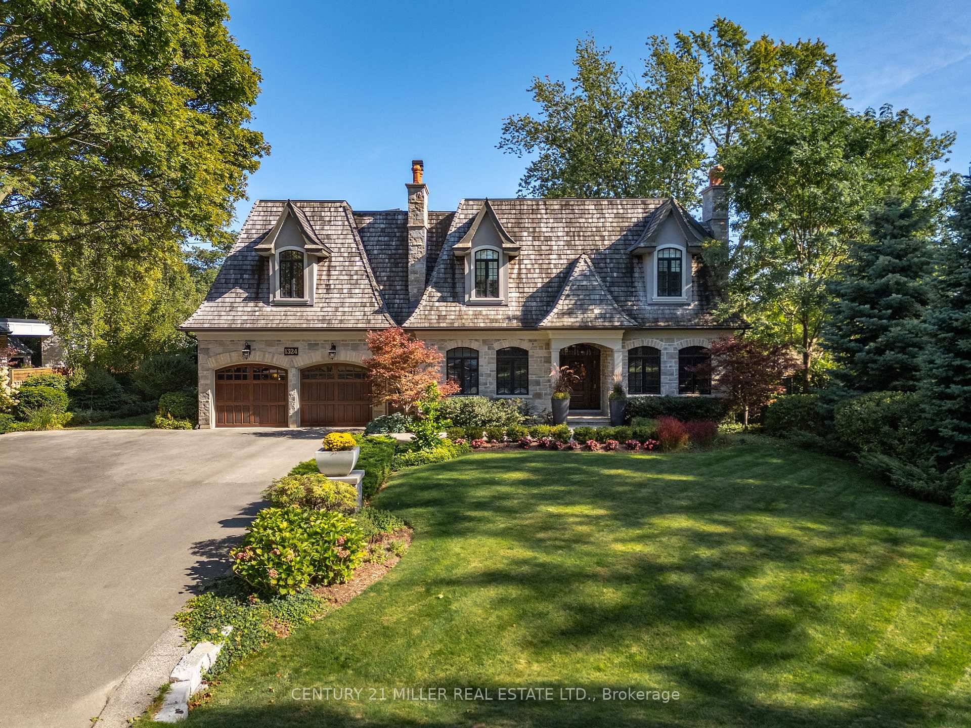 Welcome to 1324 Cambridge Drive, a timeless French inspired custom home that blends classic stone architecture with cedar roofing and flagstone walkways.