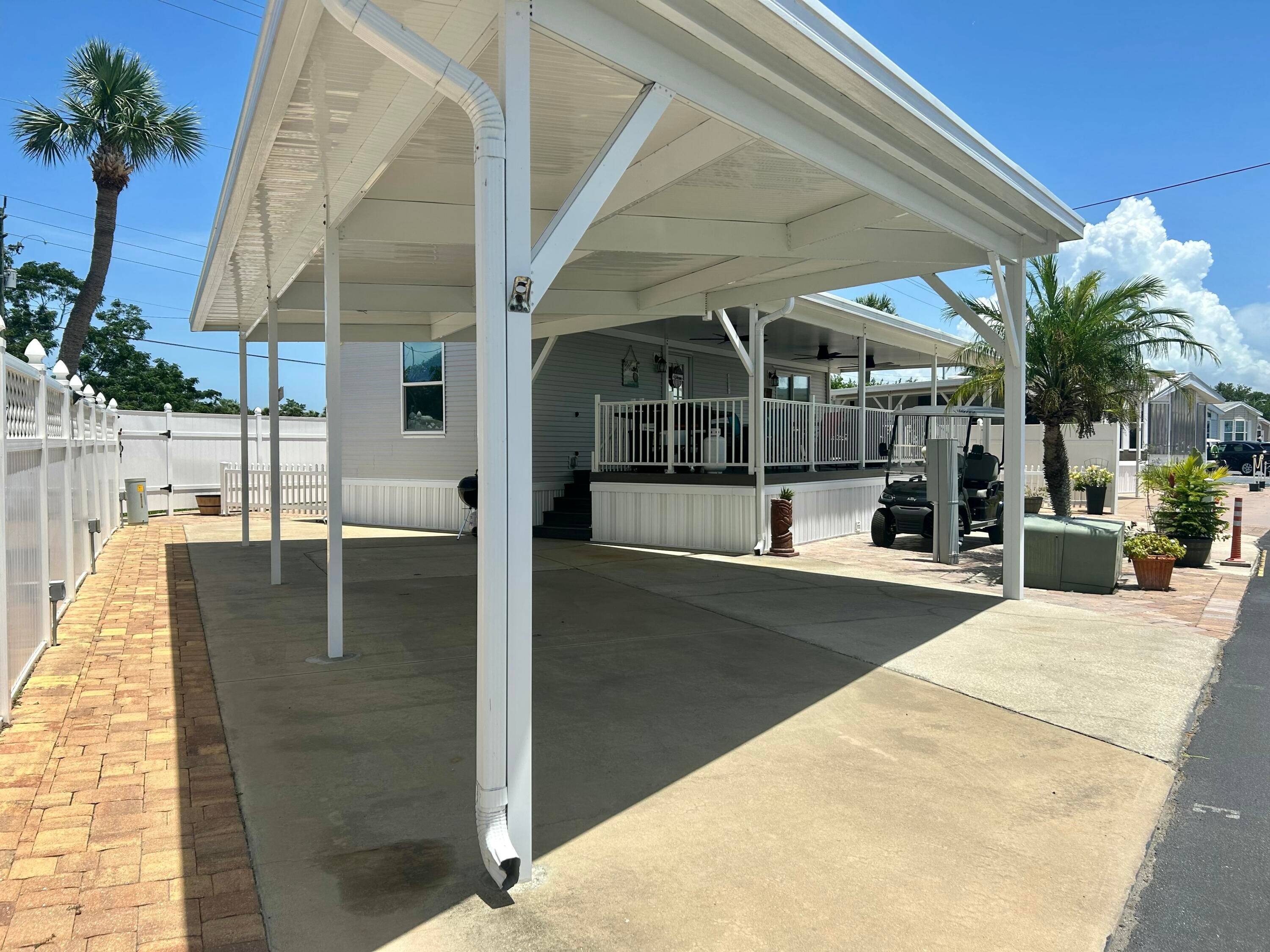 Enjoy Florida living in this 2019 Palm Harbor park model on a double lot with plenty of space and 23x33 carport for parking.