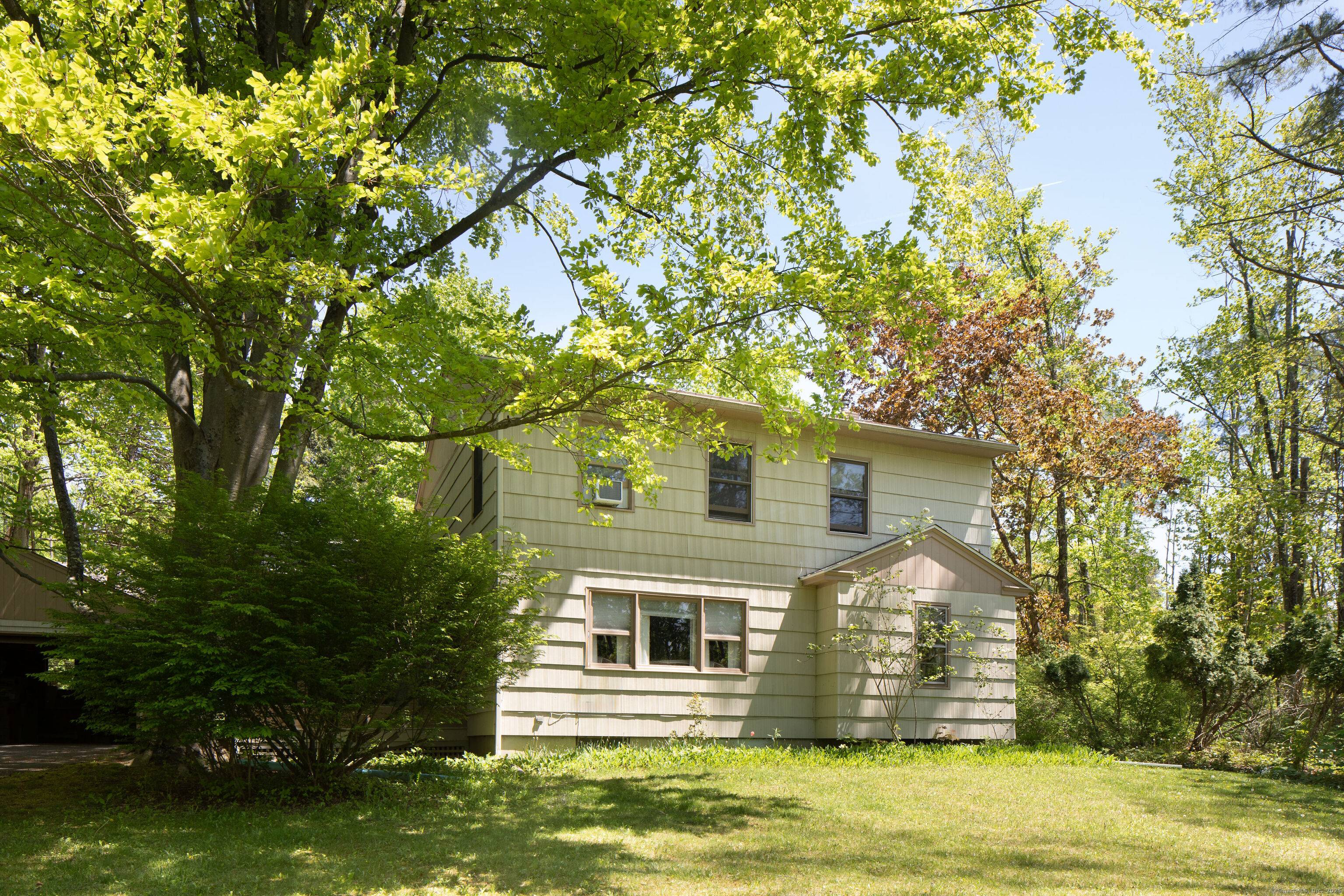 Beautifully maintained home sits above the road with nicely landscaped yard, paved driveway and two car garage with an additional car port.