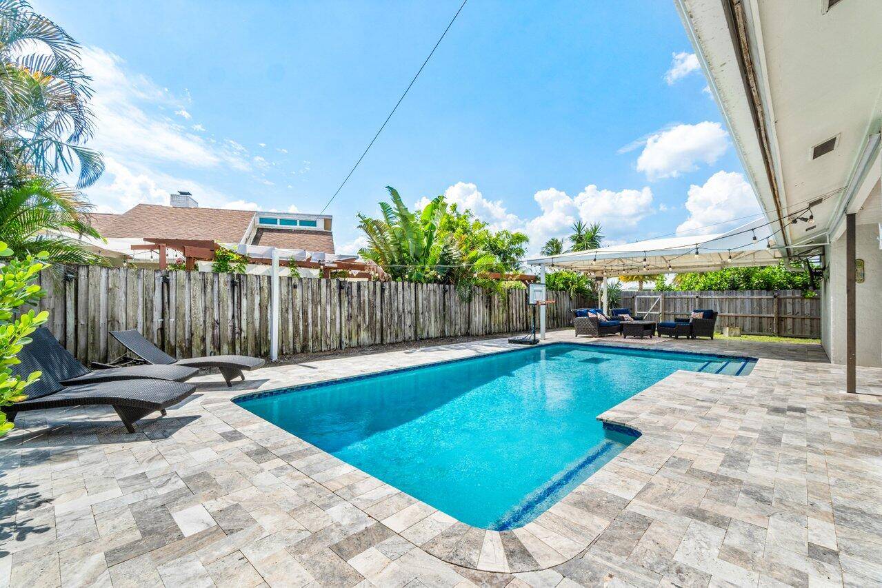 This beautifully furnished 4 bed, 2 bath pool home is situated on a spacious corner lot in the heart of Wellington.