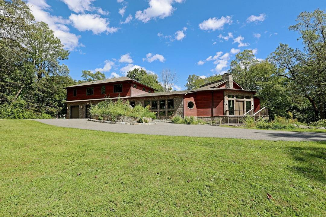 Architecturally significant modern home, influenced by the works of Frank Lloyd Wright Philip Johnson, nestled privately on 2 acres at the end of a cul de sac in sought after ...