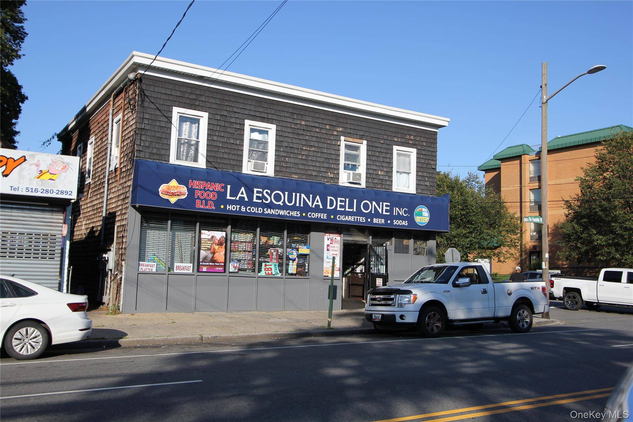 Profitable commercial building featuring a double store on the first floor, currently operating as a grocery and deli, with two newly renovated apartments above.