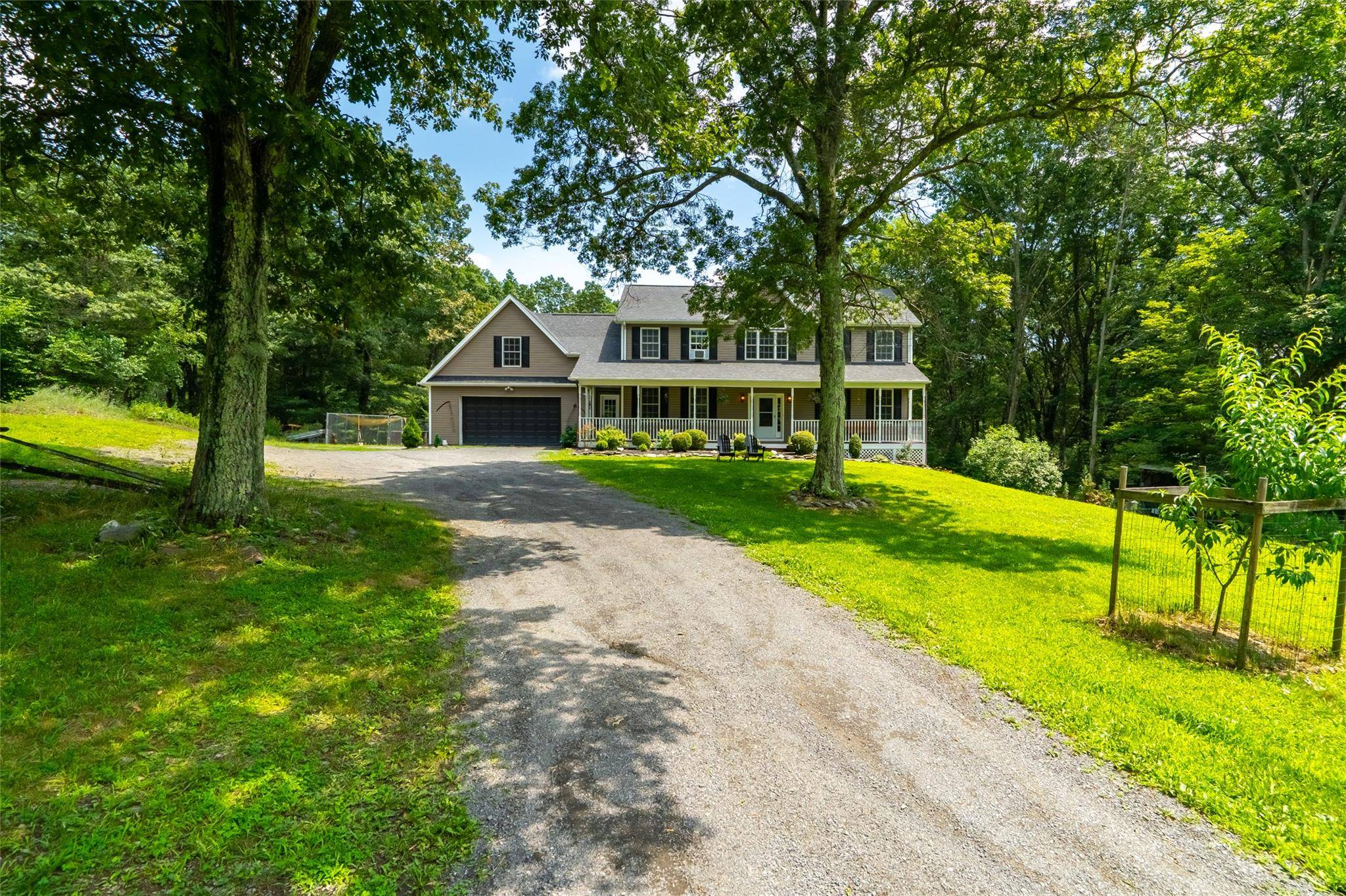 Beautiful Colonial lives like a 4 bedroom featuring a covered porch with wooden rocking bench.