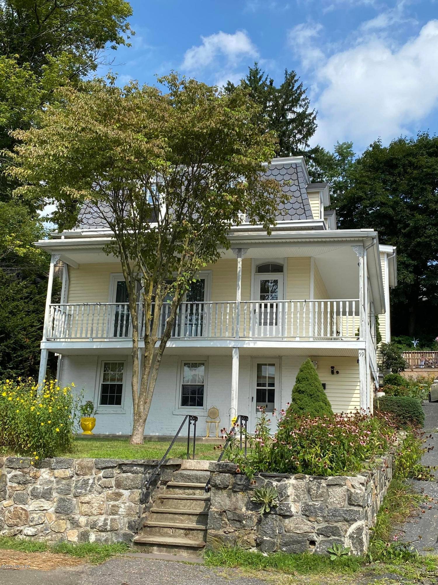 Fabulous gardens enhance the private patio pool w deck of this charming Mansard roofed home.