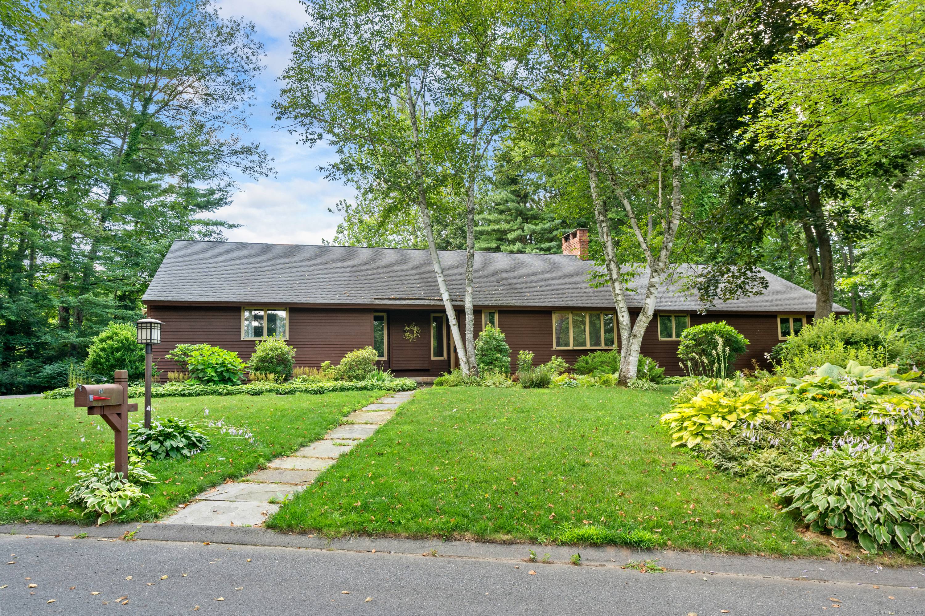 A contemporary ranch with peaceful views of a gurgling brook running along the backyard includes birds and wildlife from a large deck and handsome screened porch.