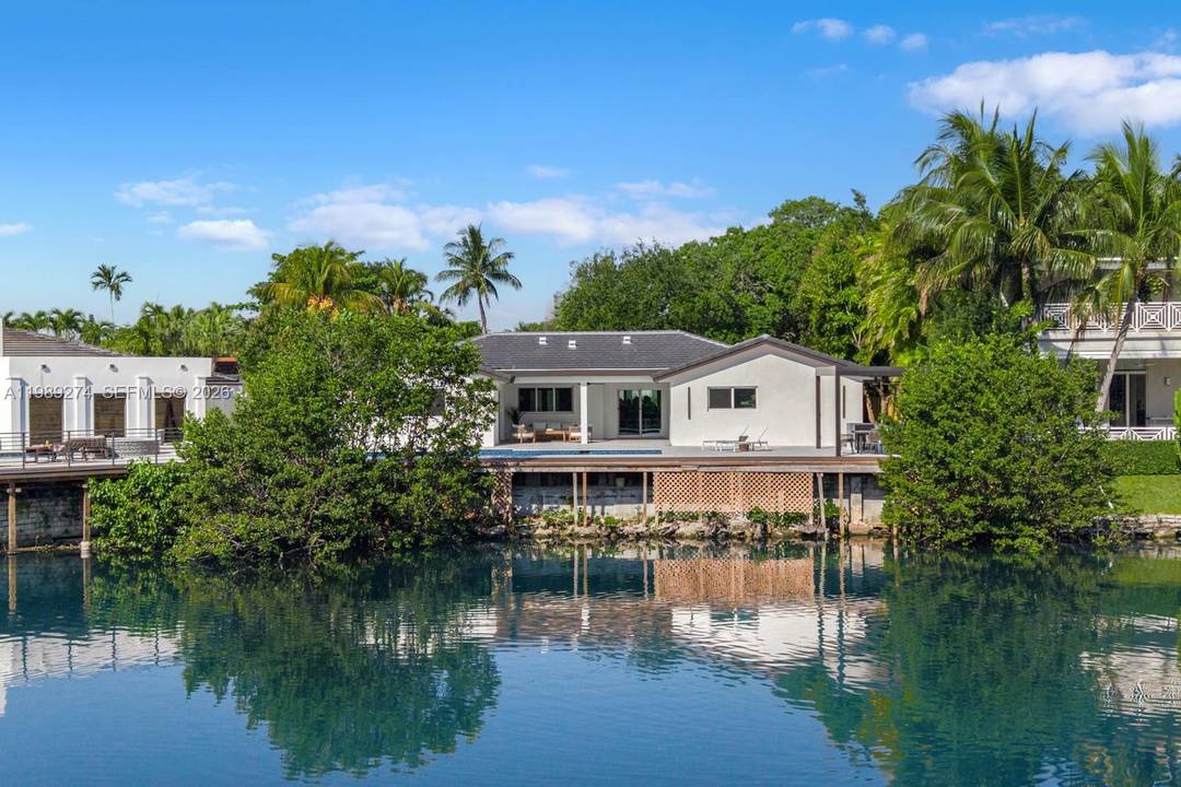 Nestled within the prestigious guard gated community of Enchanted Lakes, this impeccably renovated waterfront residence embodies refined South Florida living.
