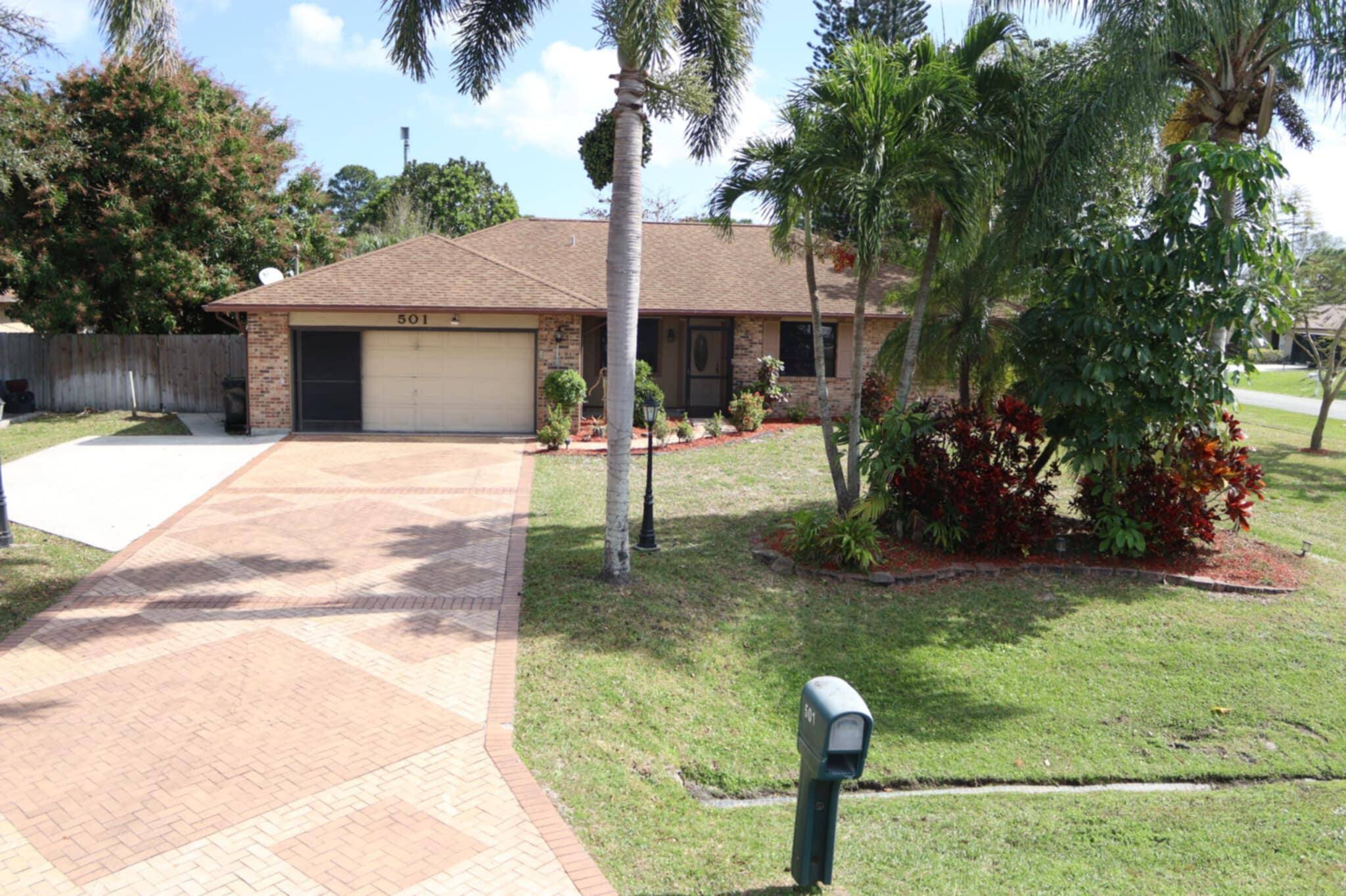 This charming brick front home sits on a large fenced corner lot, complete with mango and avocado trees.