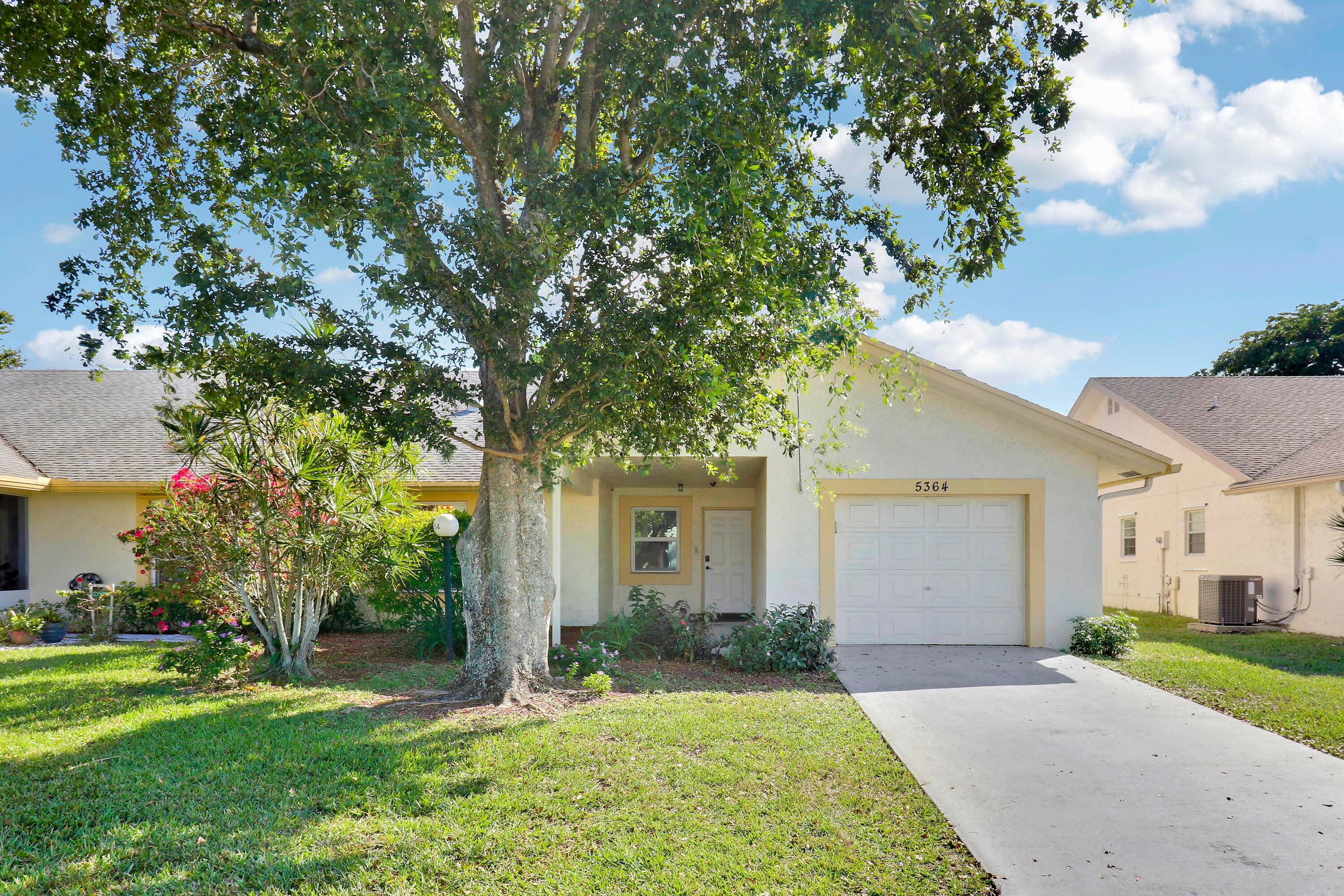 Welcome to 5364 Crystal Anne Drive, a rarely available 2 bedroom, 2 bathroom home with an enclosed office, nestled within the gated community of Cypress Lakes in West Palm Beach.