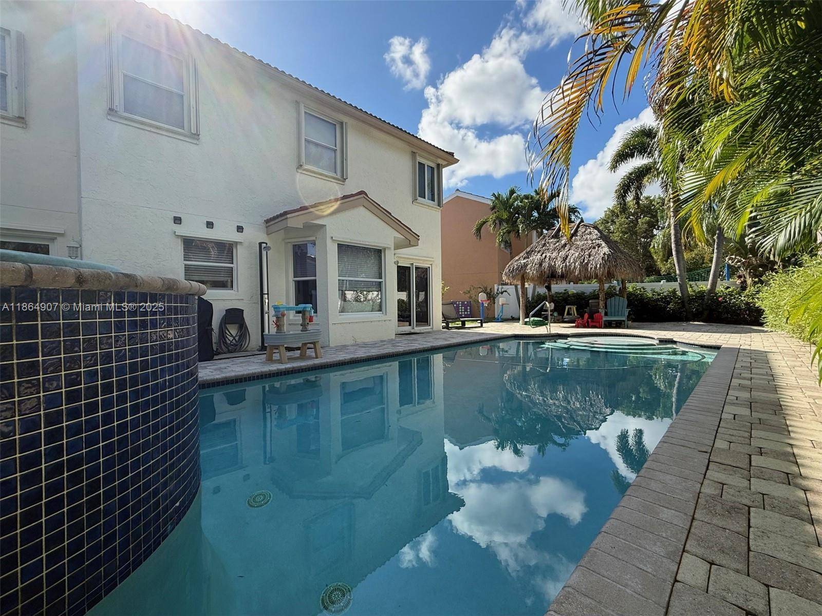Welcome to your private South Florida Oasis with a heated saltwater pool with a waterfall, an oversized lot, an outdoor shower and amazing Tiki hut for shade and privacy !