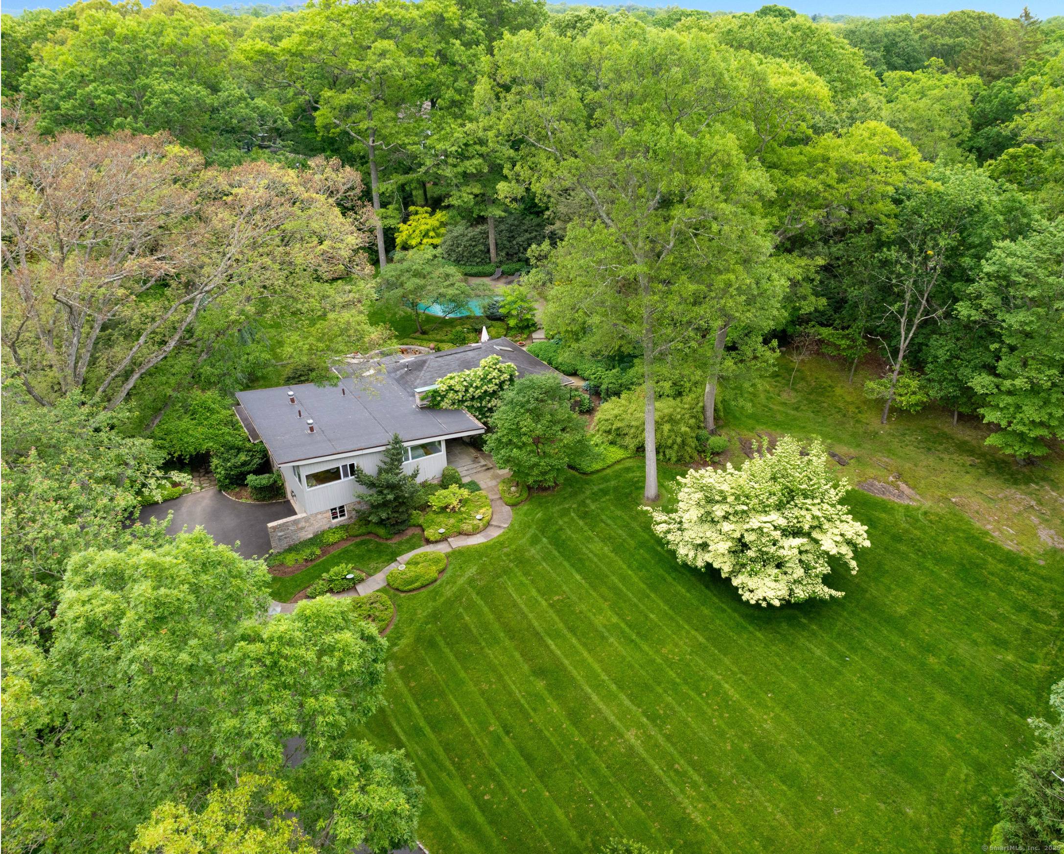 Experience the best of Westport living in this stunning Mid Century Modern residence set on 1.