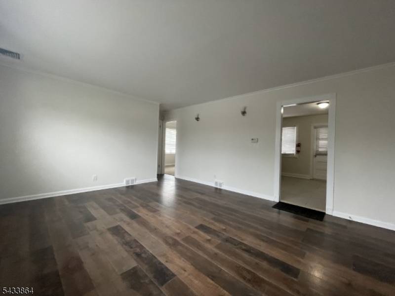 Updated home featuring newer kitchen with wood cabinetry, tile backsplash, tile flooring, and stainless steel appliances including gas range and built in microwave.