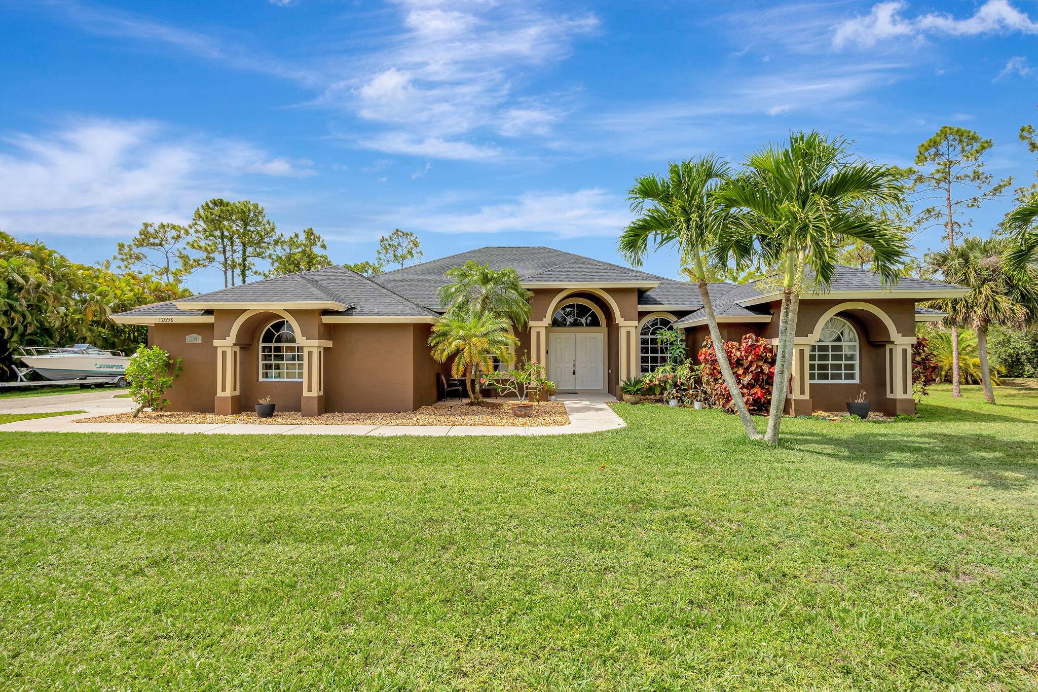 Welcome to this impeccably maintained home located in The Acreage, situated on a spacious 1.