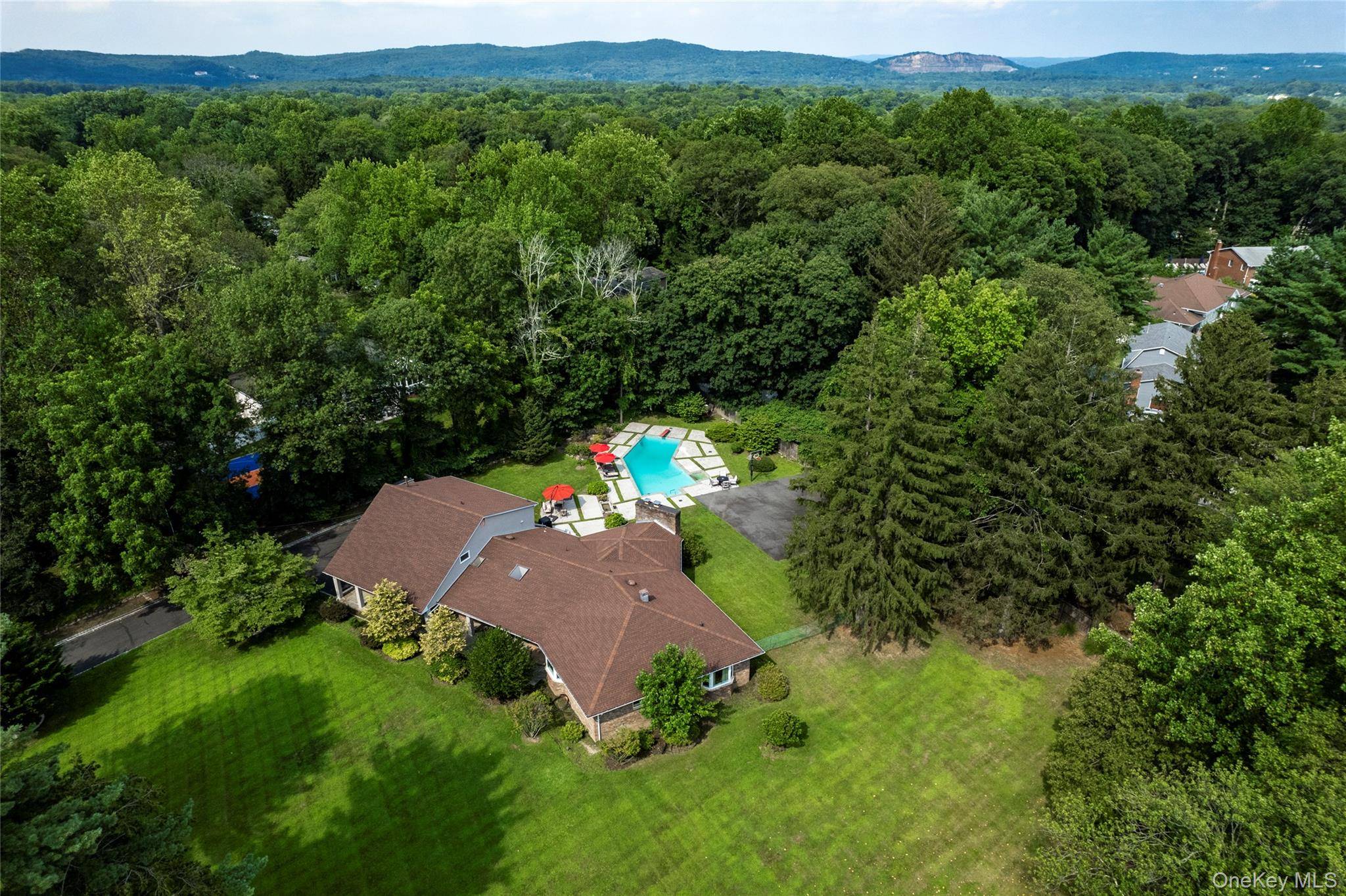 Tucked away on a gently winding country road in the heart of New City, this stately all brick and stucco residence offers a rare combination of elegance, privacy, and versatility.