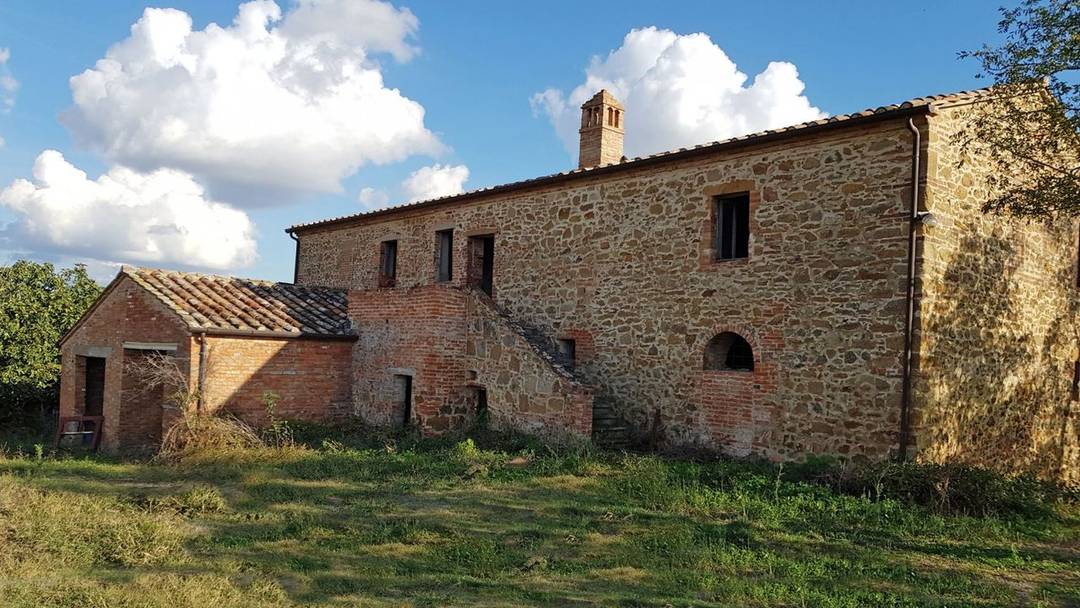 Tuscany, to be restored farmhouse for sale close to Siena. The main building houses wine cellars. Property land in landscaped setting.