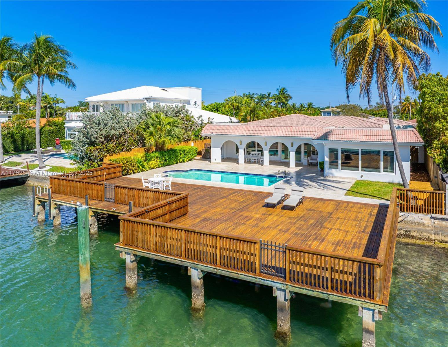 Indulge in waterfront living on Biscayne Bay, this one story home seamlessly blends Miami Beach luxury with timeless serenity.