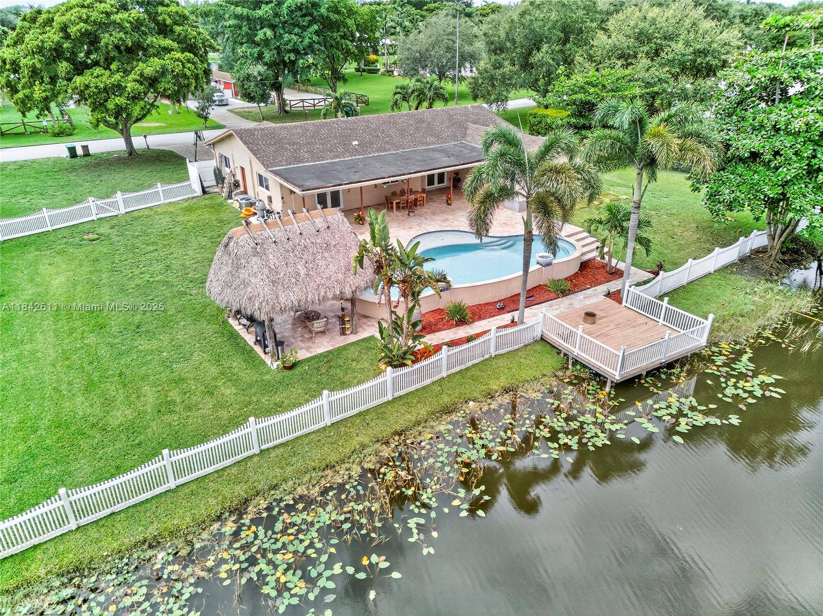 LUXURY OASIS ON A SPRAWLING BUILDERS ACRE LAKEFRONT LOT IN DAVIE WEST !