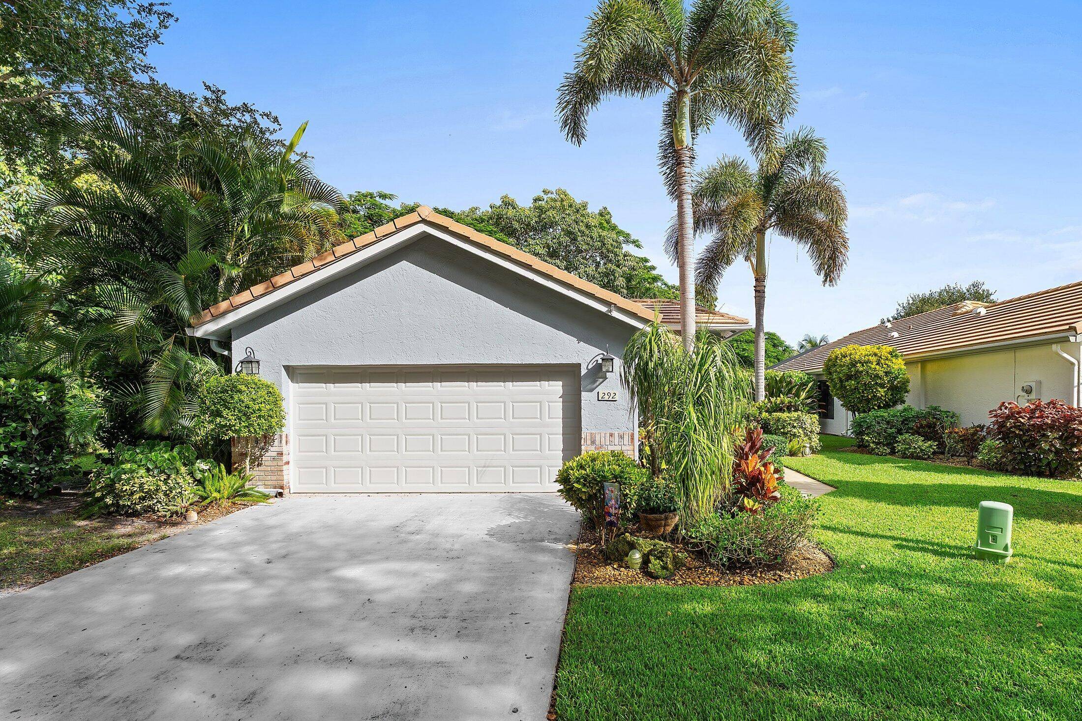 Paradise found ! Set against a backdrop of blossoming tropical plants and trees nestled in a private community just 5 minutes from Downtown Delray.