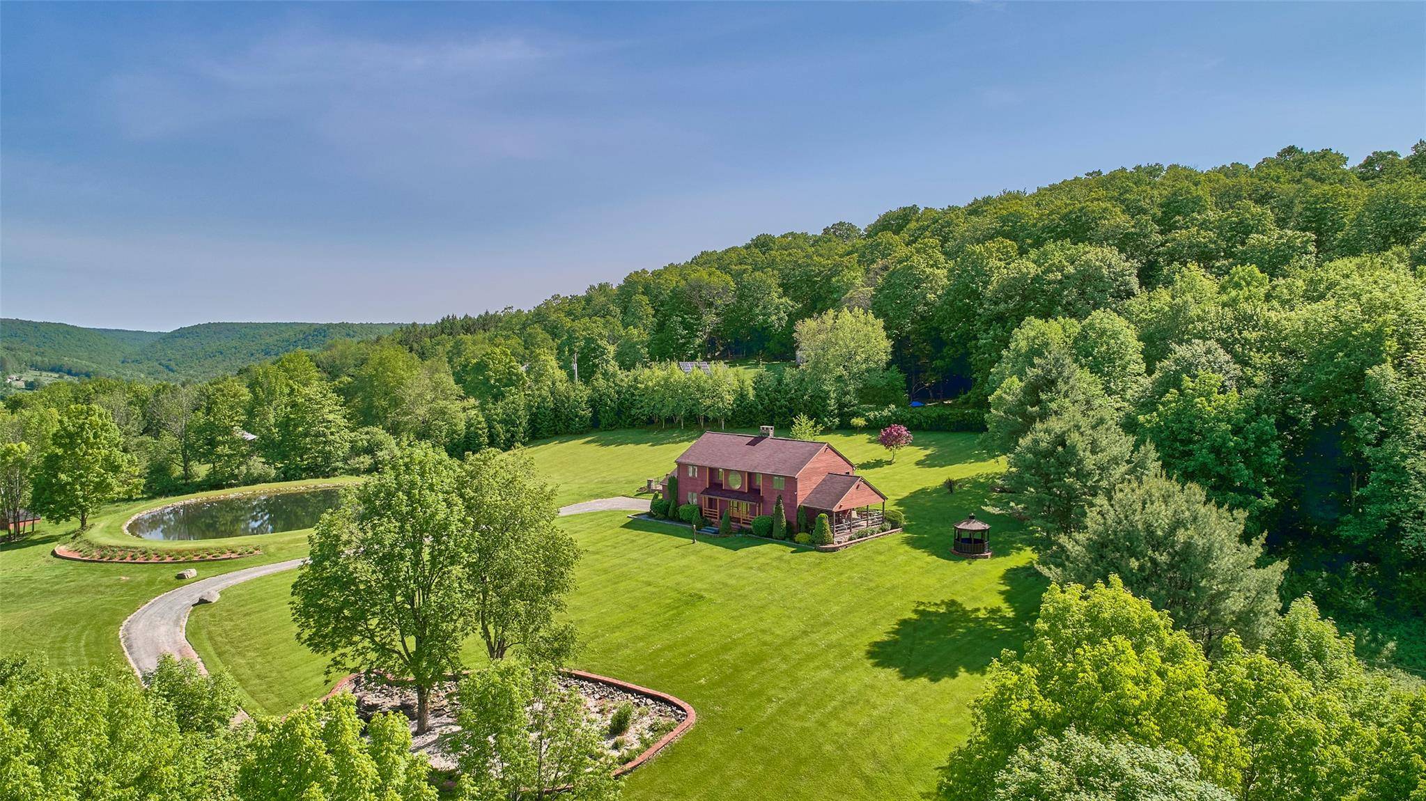 This mountaintop contemporary sits on 15 private acres with unparalleled views of the western Catskills, miles of hills and valleys, and an expansive, rolling lawn.