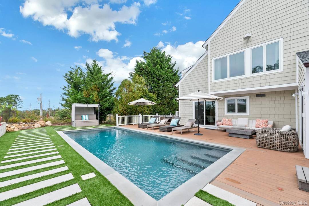 Experience refined Hamptons living in this exceptional Hampton Bays Post Modern retreat on coveted Old Canoe Place Road.