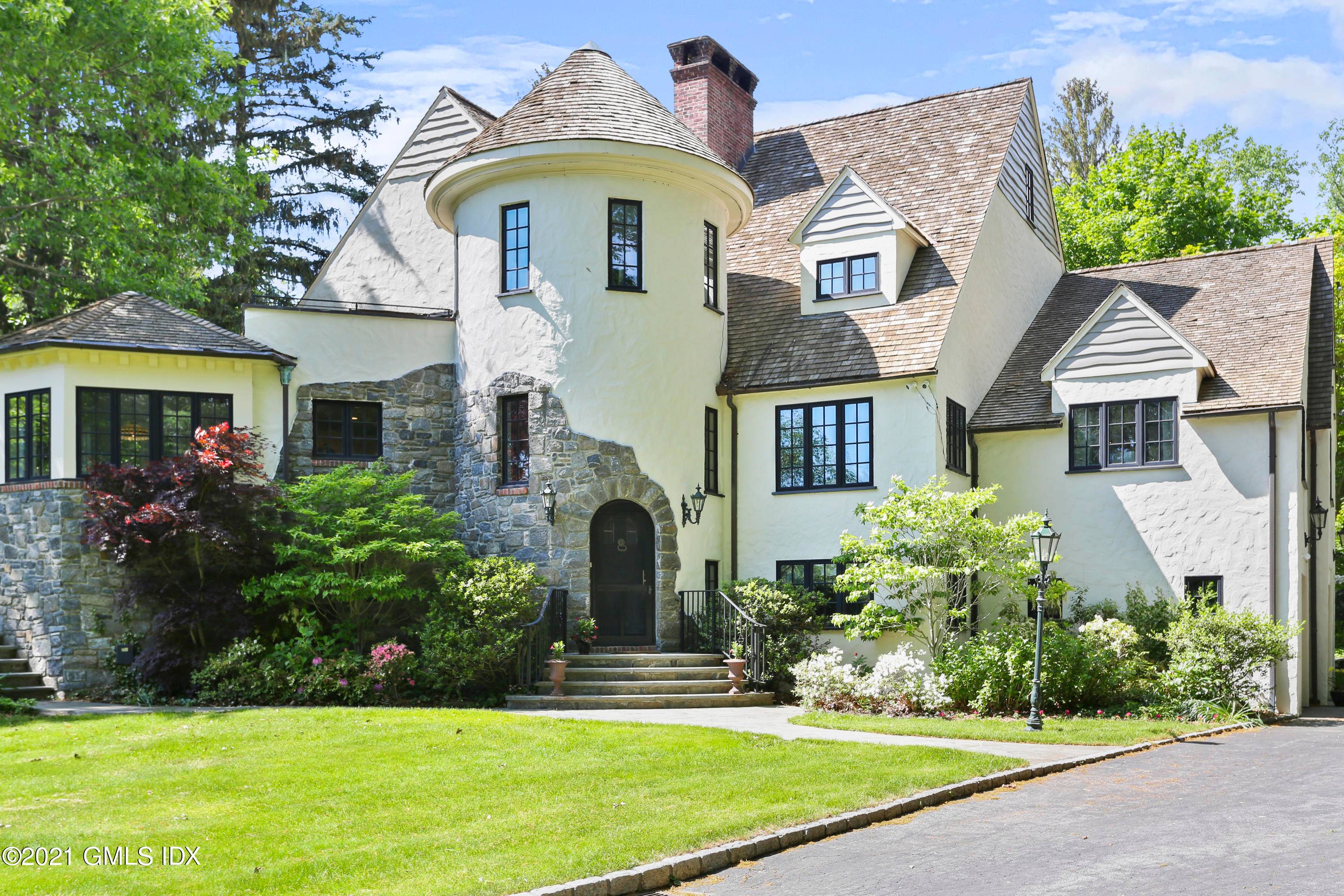 Private lakefront five bedroom English Tudor with bridge, idyllic water views and launch dock is tucked away on 2.