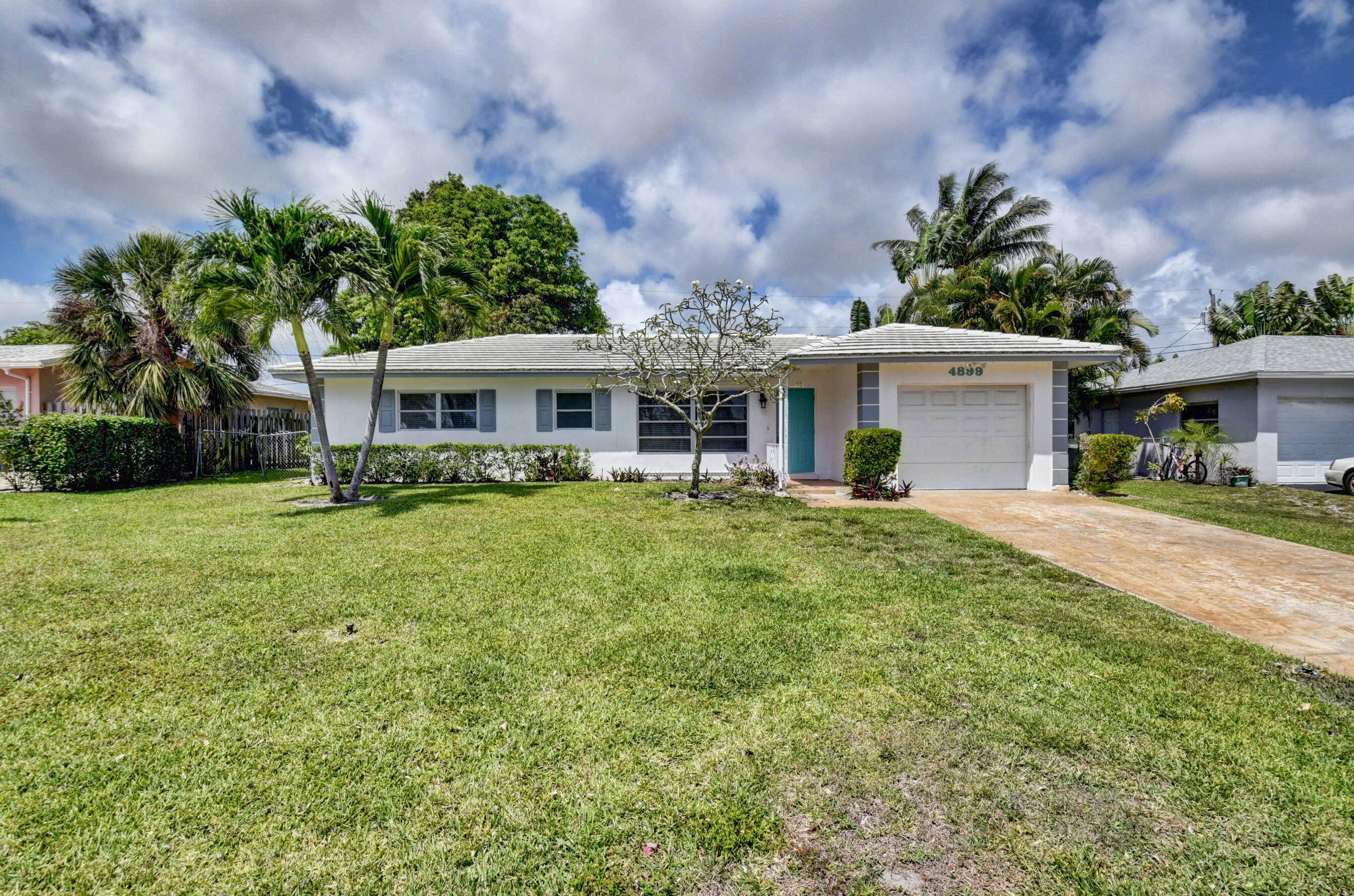 Lovely 2 bedroom, 2 bath house with updated kitchen, polished terrazzo floors throughout, painted in neutral tones, large covered screen patio overlooks the fully fenced backyard.